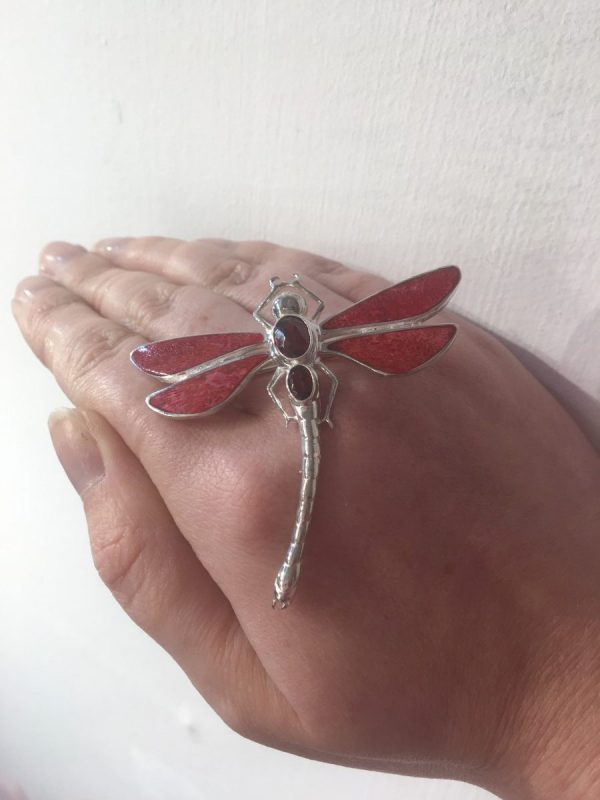 red dragonfly brooch shown on hand