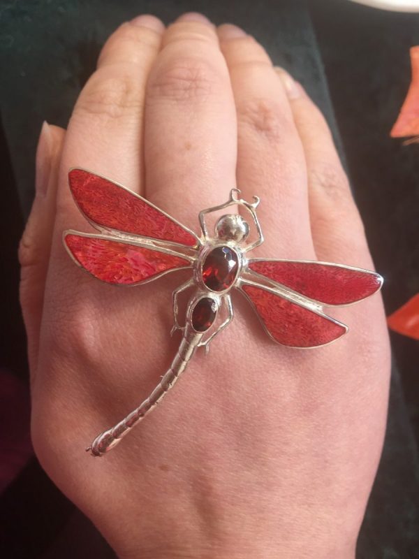 red dragonfly brooch shown on hand