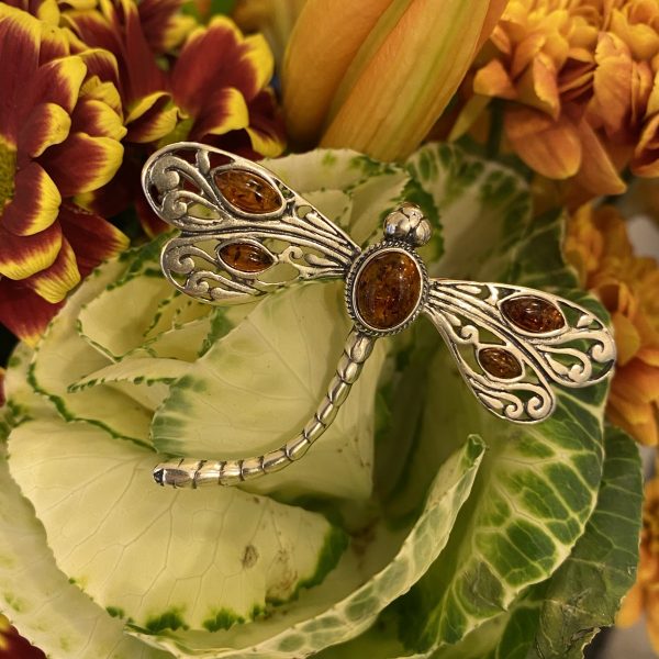 amber dragonfly brooch on flowers